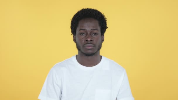 Ung afrikansk Man gestikulerande tummen ner isolerad på gul bakgrund — Stockvideo