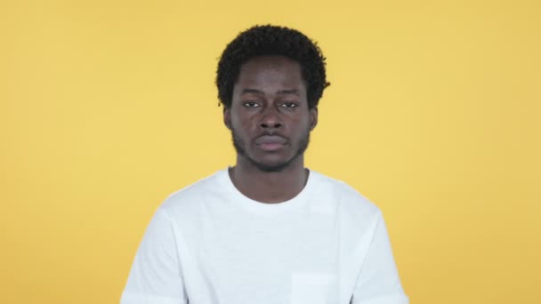 黄色の背景に分離カメラを見てアフリカ青年 — ストック動画