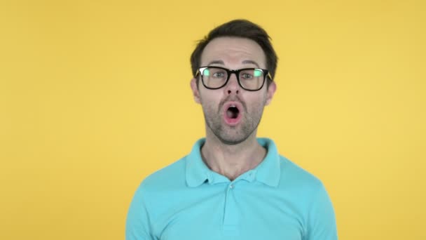 Wow, gelukkig verbaasd jonge man verrast door geschenk geïsoleerd op gele achtergrond — Stockvideo