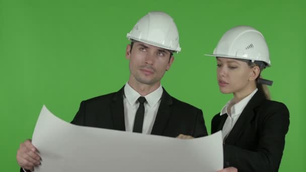 Ingenieros masculinos y femeninos satisfechos que estudian el plano de la construcción, llave del croma — Vídeos de Stock
