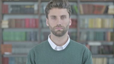 Genç adam kameraya bakıyor.