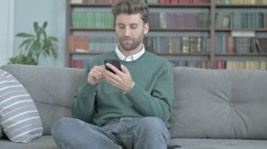 Genç Adam Akıllı Telefonunda Geziniyor ve Kutluyor