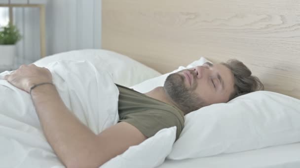 Ung man sover på sängen hemma — Stockvideo