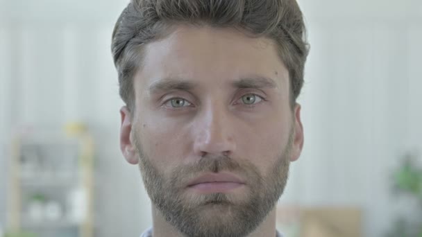 Портрет серьезного молодого человека, смотрящего в камеру — стоковое видео
