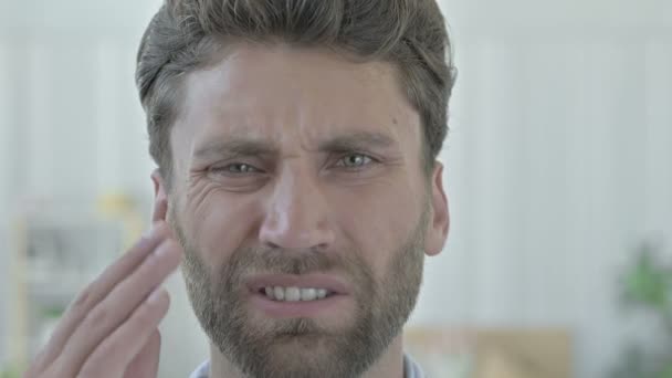 Portret van ongelukkig jonge man terwijl het hebben van tandpijn — Stockvideo