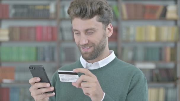 Young Man using Credit Card on his Cellphone — Stock Video