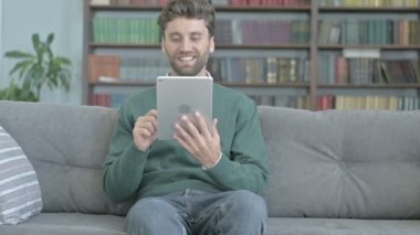 Kanepede Otururken Tablet üzerinde Happy Man Görüntülü Arama