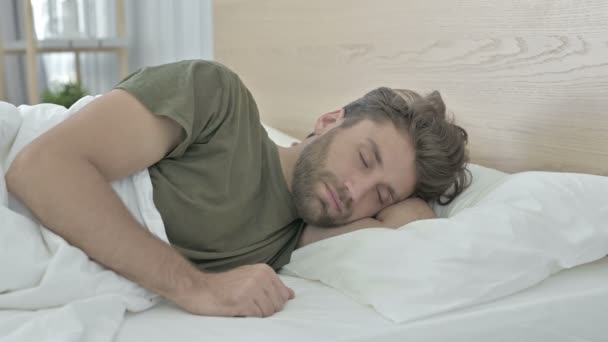 Unavený mladý muž s bolestí krku při spaní v posteli — Stock video