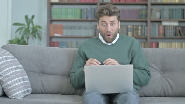 Jovem ficando chocado enquanto trabalhava no laptop — Vídeo de Stock