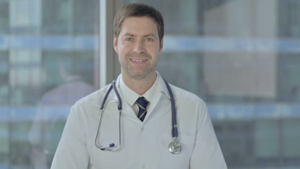 Doctor positivo sonriendo a la cámara — Vídeos de Stock