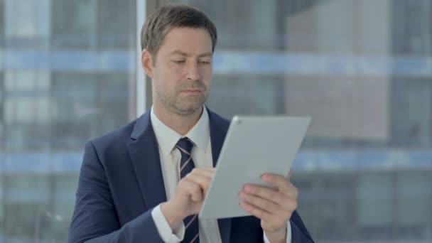 Geschockter Geschäftsmann greift zum Tablet und regt sich auf — Stockvideo