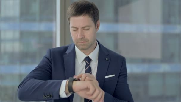 Empresário ambicioso usando relógio inteligente — Vídeo de Stock