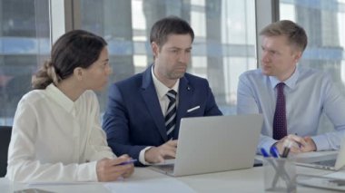 Yönetici İş adamları Office Table'da Dizüstü Bilgisayar aracılığıyla Rapor paylaşımı