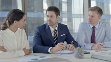 Orta Yaşlı İşadamı Ofis Masasında Yardımcıları ile Sohbet Ediyor