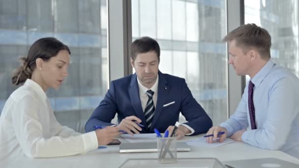 Middelbare leeftijd zakenman met een ontmoeting met zijn assistenten in boardroom — Stockvideo