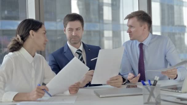 Les gens d'affaires exécutifs ayant des arguments sur les documents alors qu'ils sont assis sur la table du bureau — Video