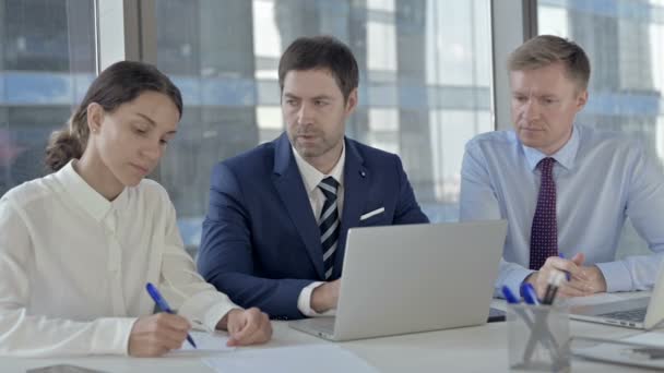 Empresario de mediana edad compartiendo informe a sus asistentes en su computadora portátil — Vídeos de Stock