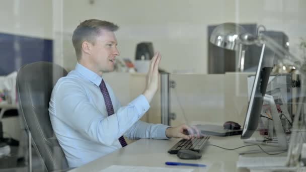 Młody przystojny biznesmen robi Video Chat na komputerze biurowym — Wideo stockowe