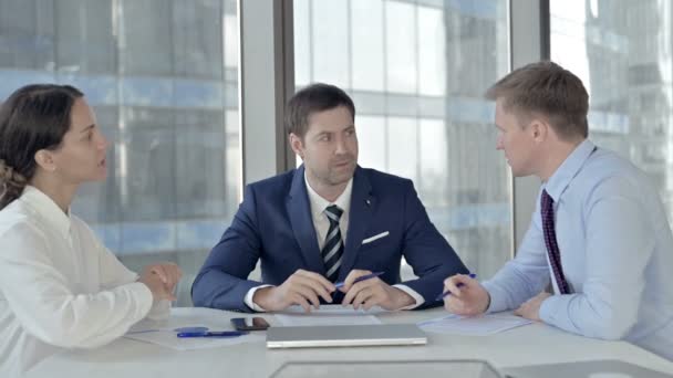 Middelbare leeftijd zakenman vergadering met zijn assistenten op Boardroom tafel — Stockvideo