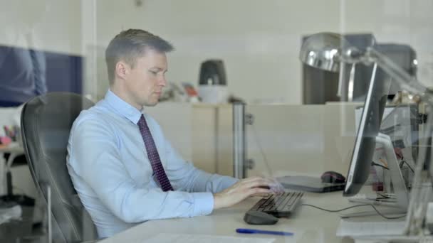 Müder junger Geschäftsmann arbeitet am Bürocomputer und hat Kopfschmerzen — Stockvideo