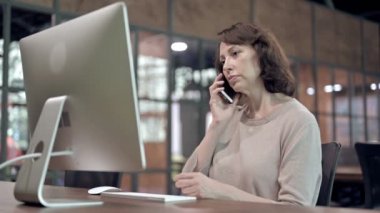 Yaşlı Kadın İş Yerinde Telefonda Konuşuyor