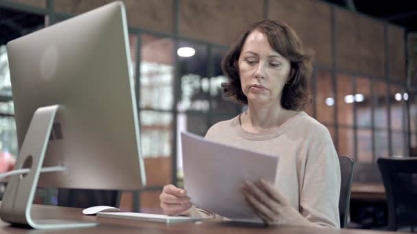 Creatieve vrouw die documenten op het werk bestudeert — Stockvideo