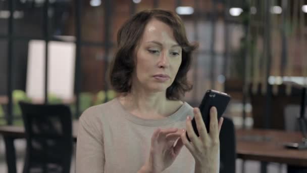 Positieve oude vrouw die smartphone applicaties gebruikt — Stockvideo