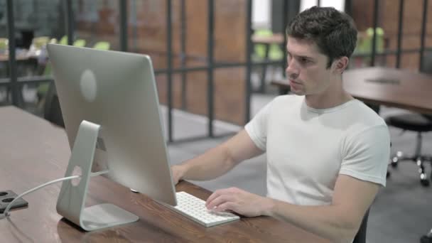 Hombre joven que trabaja en la computadora en línea — Vídeo de stock