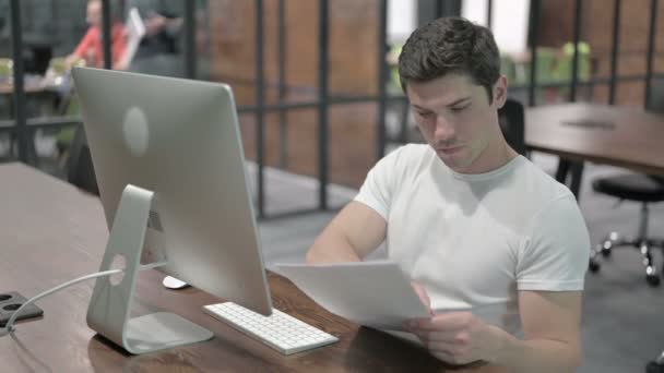 Papierkram eines kreativen jungen Mannes im Büro — Stockvideo