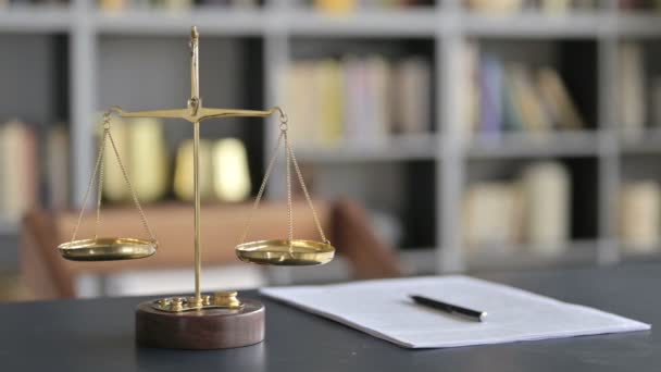 Масштаб баланса золотой латуни с документом на столе юриста — стоковое видео