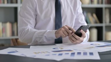 İş adamının Yakın Çekimi Cep Telefonu ile Belgeler Üzerinde Çalışıyor