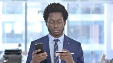 Cep telefonunda kredi kartı kullanan Afrikalı Amerikalı İşadamı