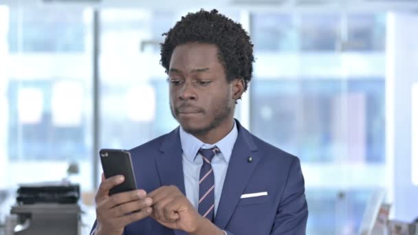 Cellulare di scorrimento dell'uomo d'affari afroamericano ambizioso — Video Stock