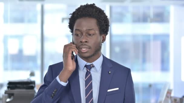 Афроамериканский бизнесмен кричит во время разговора по мобильному телефону — стоковое видео