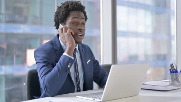 Afrikai-amerikai üzletember használja a mobiltelefon Office Desk — Stock videók