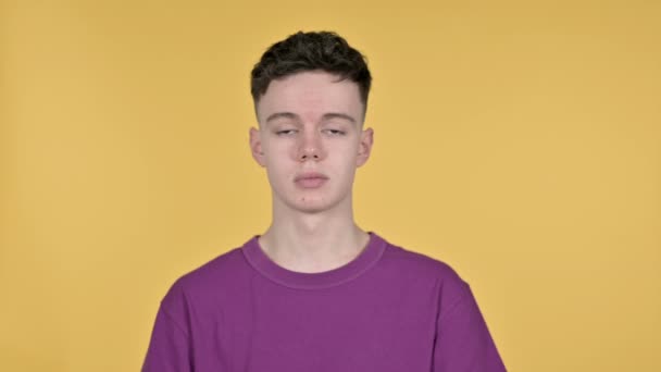 Mladý muž mávající prstem odmítnout na žlutém pozadí — Stock video