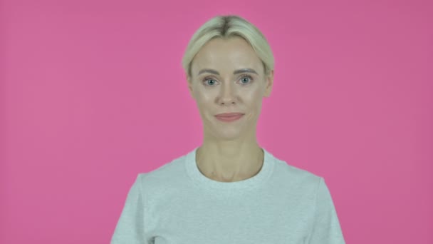 Fiatal nő integető kéz Üdvözöljük a rózsaszín háttér — Stock videók