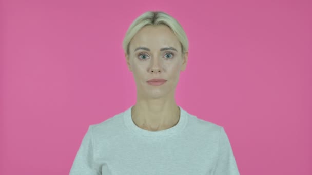 Знак победы молодой женщины на розовом фоне — стоковое видео