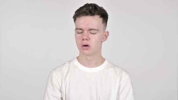 Молодий чоловік позіхає і напружує тіло на білому фоні — стокове відео