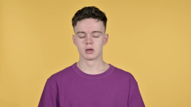 Junger Mann mit Kopfschmerzen auf gelbem Hintergrund — Stockvideo