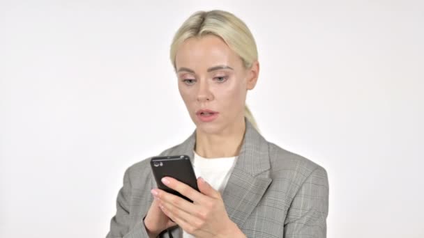 Femme d'affaires choquée utilisant un téléphone intelligent, fond blanc — Video