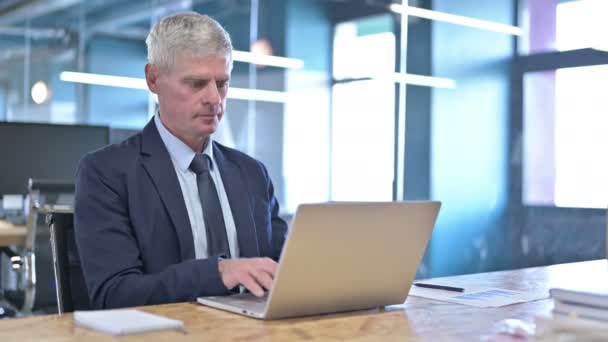 Амбициозный бизнесмен среднего возраста, работающий над ноутбуком — стоковое видео