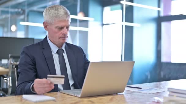 Uomo d'affari deluso di mezza età che utilizza carta di credito sul computer portatile — Video Stock