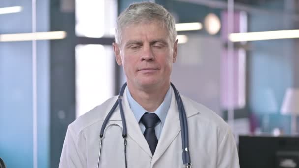 Porträt eines ernsthaften Arztes mittleren Alters, der in die Kamera blickt — Stockvideo