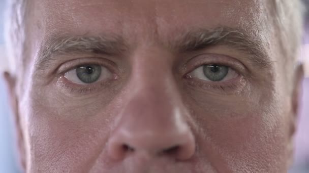 Primer plano de los ojos serios del hombre de mediana edad mirando a la cámara — Vídeo de stock