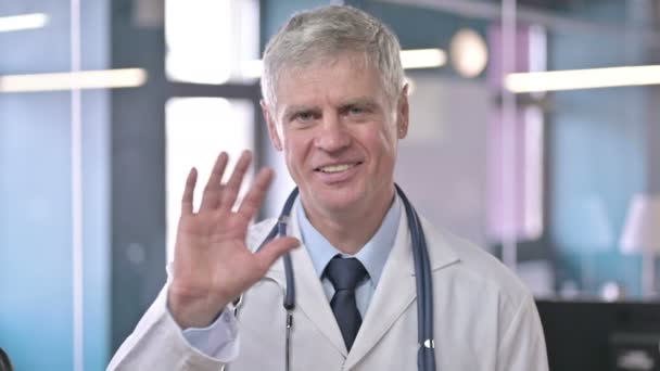 Porträt eines ehrgeizigen Arztes mittleren Alters, der redet und winkt — Stockvideo