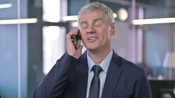 Retrato del alegre hombre de negocios de mediana edad que habla por teléfono celular — Vídeos de Stock