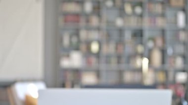 Orta yaşlı bir adamın portresi geri geliyor ve dizüstü bilgisayarın önünde oturuyor.