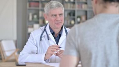 Ofiste otururken hastayla sohbet eden profesyonel doktor.