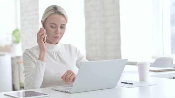 Jonge zakenvrouw in gesprek op mobiele telefoon in Modern Office — Stockvideo